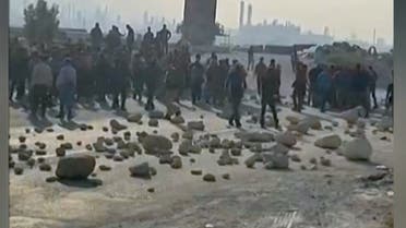 This image grab from a UGC video made available on twitter on October 10, 2022 reportedly shows employees blocking a road leading to the Asaluyeh Petrochemical Refinery in Iran's southwestern Bushehr province. A wave of unrest has rocked Iran since 22-year-old Masha Amini died on September 16 after her arrest by the morality police in Tehran for allegedly breaching the country's strict rules on hijab headscarves and modest clothing. (Photo by UGC / AFP) / NO USE AFTER OCTOBER 19, 2022 21:00:00 GMT - ISRAEL OUT - NO RESALE - NO INTERNET / RESTRICTED TO EDITORIAL USE - MANDATORY CREDIT AFP - SOURCE: UGC - ANONYMOUS - NO MARKETING - NO ADVERTISING CAMPAIGNS - NO INTERNET - DISTRIBUTED AS A SERVICE TO CLIENTS - NO RESALE - NO ARCHIVE -NO ACCESS ISRAEL MEDIA/PERSIAN LANGUAGE TV STATIONS OUTSIDE IRAN/ STRICTLY NO ACCESS BBC PERSIAN/ VOA PERSIAN/ MANOTO-1 TV/ IRAN INTERNATIONAL/RADIO FARDA - AFP IS NOT RESPONSIBLE FOR ANY DIGITAL ALTERATIONS TO THE PICTURE'S EDITORIAL CONTENT - RESTRICTED TO EDITORIAL USE - MANDATORY CREDIT AFP - SOURCE: UGC - ANONYMOUS - NO MARKETING - NO ADVERTISING CAMPAIGNS - NO INTERNET - DISTRIBUTED AS A SERVICE TO CLIENTS - NO RESALE - NO ARCHIVE -NO ACCESS ISRAEL MEDIA/PERSIAN LANGUAGE TV STATIONS OUTSIDE IRAN/ STRICTLY NO ACCESS BBC PERSIAN/ VOA PERSIAN/ MANOTO-1 TV/ IRAN INTERNATIONAL/RADIO FARDA - AFP IS NOT RESPONSIBLE FOR ANY DIGITAL ALTERATIONS TO THE PICTURE'S EDITORIAL CONTENT