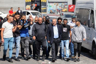 Arab-Israeli Knesset member Ahmad Tibi walks in the Palestinian Shuafat refugee camp, on October 11, 2022, as Israeli security forces continue a manhunt for a Palestinian suspected of killing an 18-year-old military policewoman on October 8 in Israeli-annexed east Jerusalem. (AFP)