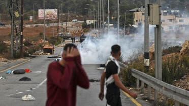 Young Palestinian protesters run from tear gas fired by Israeli security forces during confrontations at the northern entrance to the occupied West Bank city of Ramallah, on October 12, 2022. (Photo by Abbas MOMANI / AFP)
