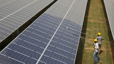 Workers clean photovoltaic panels inside a solar power plant in Gujarat, India. (File photo: Reuters)