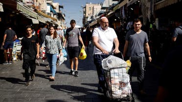 Shoppers carry their groceries through Mahane Yehuda market in Jerusalem, September 30, 2022. REUTERS/Amir Cohen
