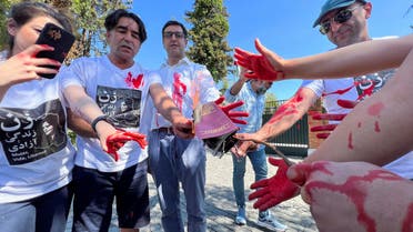 Iranian community members living in Chile burn an Iran passport as they protest outside Iran's embassy in Chile in solidarity with Iranian women, in Santiago, Chile, October 14, 2022. (Reuters)