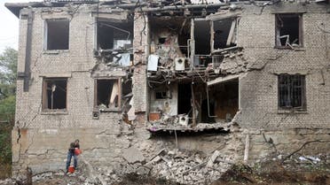 TOPSHOT - A local resident cleans debris next to a residential building destroyed by a missile strike in Konstantinovka in the eastern Donetsk region on October 14, 2022. (Photo by Anatolii Stepanov / AFP)