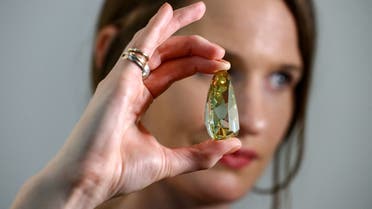 Sophie Stevens, a jewelry specialist at Sotheby’s, holds the Golden Canary, a 303.10-carat diamond in Dubai, United Arab Emirates, October 17, 2022. (Reuters)