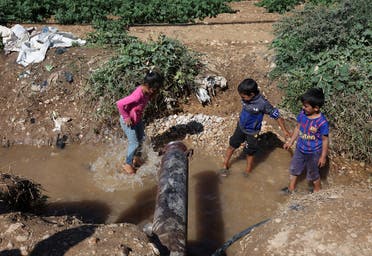 Syrian refugee children play in muddy water in Qab Elias, in Lebanon's Bekaa Valley October 18, 2022. (File photo: Reuters)