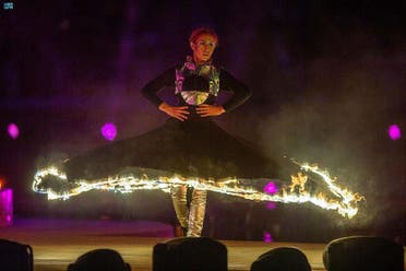 Un artista luce un vestido de llamas al inicio de la temporada 2022 en Riad (SPA)