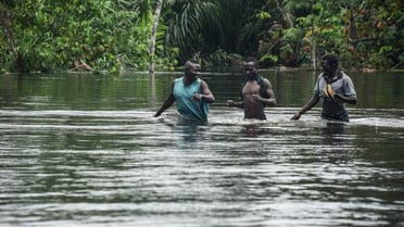 People walk along the East-West highway severed by flooding, bringing to a halt the movement of vehicles and economic activities, in Niger delta region of Ahoada, Rivers State, southern Nigeria, on October 21, 2022. More than 600 people are now known to have perished in the worst floods in a decade in Nigeria, according to a new toll released on October 20. The disaster had also forced more than 1.3 million from their homes, said a statement by Nigeria's ministry of humanitarian affairs, released on Twitter. (AFP)
