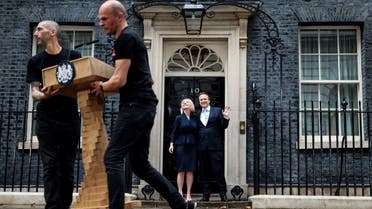 Standing outside 10 Downing Street, Britain's newly appointed Prime Minister Liz Truss poses for photographers with her husband Hugh O'Leary, as the lectern is removed, after delivering her first speech as Prime Minister in central London, on September 6, 2022. (AFP)