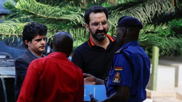 Unidentified Pakistani embassy officials talk to a police officer at the Chiromo Mortuary, following the killing of Pakistani journalist Arshad Sharif who was shot dead when police opened fire on the vehicle as it went through a roadblock without stopping, in Magadi road on the outskirts of Nairobi, Kenya, October 24, 2022. (Reuters)