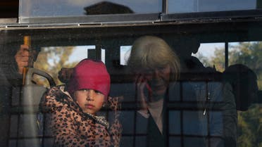 Civilians evacuated from the Russian-controlled Kherson region of Ukraine sit inside a bus upon arrival at a railway station in the town of Dzhankoi, Crimea October 24, 2022. (Reuters)