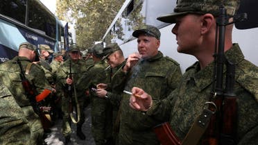 Reservists drafted during the partial mobilisation smoke next to buses as they depart for military bases, in Sevastopol, Crimea September 27, 2022. (Reuters)