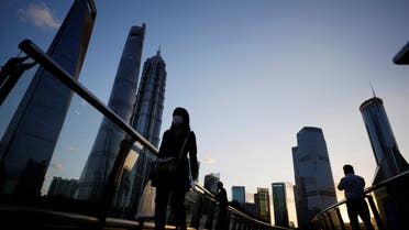 People walk on an overpass past office towers in the Lujiazui financial district of Shanghai, China October 17, 2022. (Reuters)