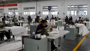 Employees work on the filter cloth production line at Jingjin filter press factory in Dezhou, Shandong province, China, on August 25, 2022. (Reuters)