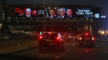 A picture shows a electoral banner for Israel’s National Unity bloc, which includes the Blue and White (Kahol Lavan) led by Defense Minister Benny Gantz, and a portrait of Likud party leader Benjamin Netanyahu (L), in Tel Aviv on October 27, 2022, ahead of the November general elections. (AFP)