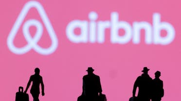  Figurines are seen in front of the Airbnb logo in this illustration. (Reuters)