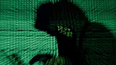 Man holds laptop computer as cyber code is projected on him in this illustration picture. (Reuters)