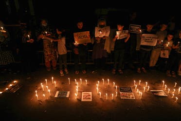 Afghan nationals, members of the Hazara minority, hold placards and candles as they protest against the suicide attack at a tutoring center in west Kabul, outside the United Nations High Commissioner for Refugees (UNHCR) office, in New Delhi, India, September 30, 2022. (Reuters)