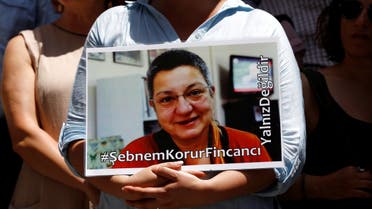 A demonstrator holds a picture of Sebnem Korur Fincanci, president of Turkey's Human Rights Foundation, during a protest against the arrest of three prominent campaigners for press freedom, in front of the pro-Kurdish Ozgur Gundem newspaper in central Istanbul, Turkey, June 21, 2016. (Reuters)
