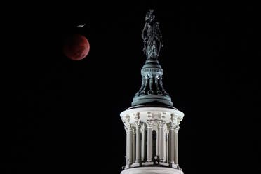 A bird flies past the moon during the lunar eclipse by the U.S. Capitol on the day of the midterm elections, in Washington, US, November 8, 2022. (Reuters(