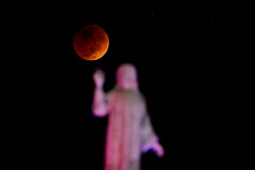The moon and a statue are seen during a lunar eclipse in San Salvador, El Salvador, November 8, 2022. (Reuters)