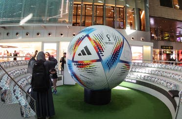 A traveler stands next to a giant football in the new central concourse building at the Hamad International Airport on November 10, 2022, in the Qatari capital Doha, ahead of the Qatar 2022 FIFA World Cup football tournament. (AFP)