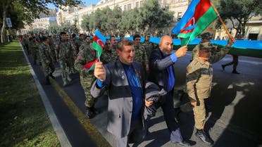 People take part in a procession marking the anniversary of the end of the 2020 military conflict over Nagorno-Karabakh breakaway region, involving Azerbaijan's troops against ethnic Armenian forces, in Baku, Azerbaijan, November 8, 2021. (Reuters)