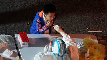A boy gets tested for the coronavirus disease (COVID-19) at a nucleic acid testing site, following the coronavirus disease (COVID-19) outbreak in Shanghai, China, November 9, 2022. REUTERS