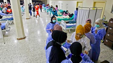 In this file photo taken on October 26, 2022, medical staffers converse at a ward for patients being treated in an outbreak of Vibrio cholera in a mosque hall converted into a field hospital in the town of Bebnine in the Akkar district in north Lebanon. (AFP)
