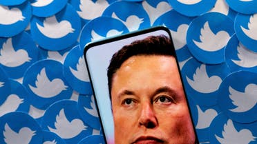 An image of Elon Musk is seen on a smartphone placed on printed Twitter logos in this picture illustration taken April 28, 2022. (File Photo: Reuters)