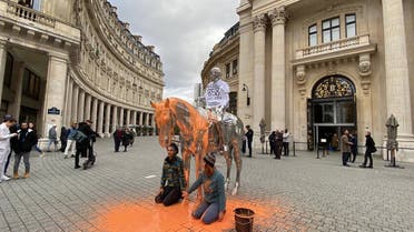 Climate activists pour orange paint on a sculptor. (Twitter)