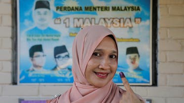 Norzihan Ab Razak, 50, shows an inked finger after voting during the country’s general election at Permatang Pauh, Penang, Malaysia November 19, 2022. (Reuters)