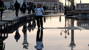 A woman takes a picture in a flooded St. Mark's Square during seasonal high water in Venice. (Reuters)