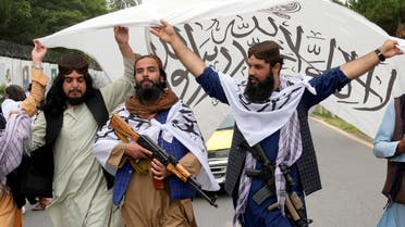 Taliban fighters hold their flag as they celebrate one year since they seized the Afghan capital, Kabul, in front of the U.S. Embassy in Kabul, Afghanistan, Monday, Aug. 15, 2022. The Taliban marked the first-year anniversary of their takeover after the country's western-backed government fled and the Afghan military crumbled in the face of the insurgents' advance. (AP Photo/Ebrahim Noroozi)