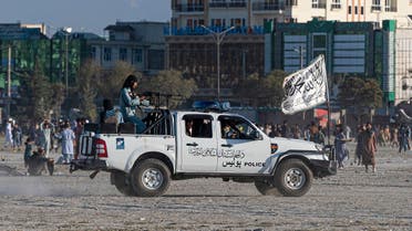 In this picture taken on October 21, 2022, Taliban fighters ride a vehicle as Afghan men play cricket at the Chaman-e-Huzuri ground in Kabul. (AFP)