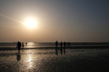 Residents enjoy the sunrise after starting their fast during the holy month of Ramadan at Ramlet al-Baida beach on Tarout Island, Saudi Arabia, April 23, 2021. (Reuters)