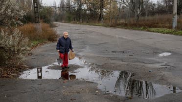 A Ukrainian woman stands next to a puddle in Kherson on November 20, 2022, amid the Russian invasion of Ukraine. (AFP)
