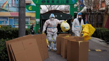 Epidemic prevention workers in protective suits put medical waste into boxes in a residential compound as outbreaks of the coronavirus disease (COVID-19) continue in Beijing, China November 27, 2022. (Reuters)