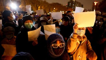 People gather for a vigil and hold white sheets of paper in protest of coronavirus disease (COVID-19) restrictions, as they commemorate the victims of a fire in Urumqi, as outbreaks of the coronavirus disease continue in Beijing, China, November 27, 2022. REUTERS/Thomas Peter