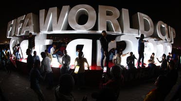 Fans take pictures with the FIFA World Cup logo on the Corniche Promenade ahead of the FIFA World Cup Qatar on November 18, 2022. (Reuters)