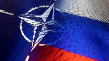 NATO and Russian flags are seen through broken glass this illustration taken April 13, 2022. (Reuters)