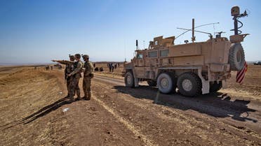 US soldiers stand near a Mine Resistant Ambush Protected (MRAP) military vehicle as they attend a joint military exercise between forces of the US-led Combined Joint Task Force-Operation Inherent Resolve coalition against the Islamic State (IS) group and members of the Syrian Democratic Forces (SDF) in the countryside of the town of al-Malikiya (Derik in Kurdish) in Syria's northeastern Hasakah province on September 7, 2022. (Photo by Delil SOULEIMAN / AFP)