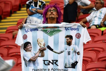 An Argentina fan holds an oversized jersey with the images of Argentina’s forward Lionel Messi (R) and former Argentina football player Diego Maradona before the Russia 2018 World Cup round of 16 football match between France and Argentina at the Kazan Arena in Kazan on June 30, 2018. (AFP)