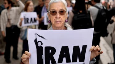 A demonstrator holds a sign during a protest in front of the Iranian embassy in Madrid, on September 28, 2022 following the death of an Iranian woman after her arrest by the country's morality police in Tehran. (AFP)