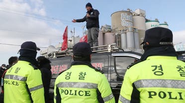 Policemen surround a unionized trucker who speaks on a van in front of a cement factory in Incheon, South Korea December 1, 2022. (Reuters)