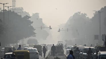 People commute along a street amid smoggy conditions in New Delhi on December 23, 2021. (AFP)