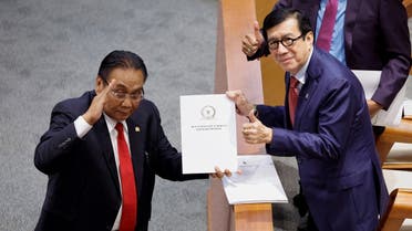 Yasonna Laoly, Indonesian Minister of Law and Human Rights, receives the new criminal code report from Bambang Wuryanto, head of the parliamentary commission overseeing the revision, during a parliamentary plenary meeting in Jakarta, Indonesia, on December 6, 2022. (Reuters)