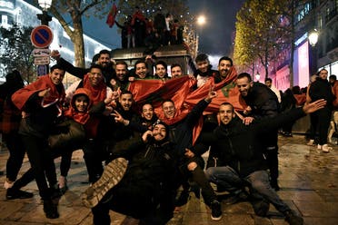 Morocco supporters wave national flags to celebrate after their team won the Qatar 2022 World Cup football match between Morocco and Spain on a street in Paris on December 6, 2022. (AFP)