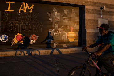 People walk and cycle past a mural featuring Brittney Griner on the side of the Footprint Center, home of the Phoenix Mercury basketball team, in Phoenix, Arizona, U.S., December 8, 2022. (Reuters)