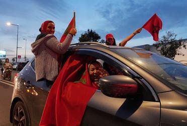 Morocco fans wave flags of Morocco from a car as they celebrate progressing to the semifinals. (Reuters)