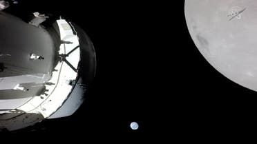 A camera on Orion’s solar array wing captures a view of the spacecraft, the Earth and the Moon during the spacecraft's outbound powered flyby of the Moon as part of the Artemis I mission on November 21, 2022, in a still image from video. (Reuters)